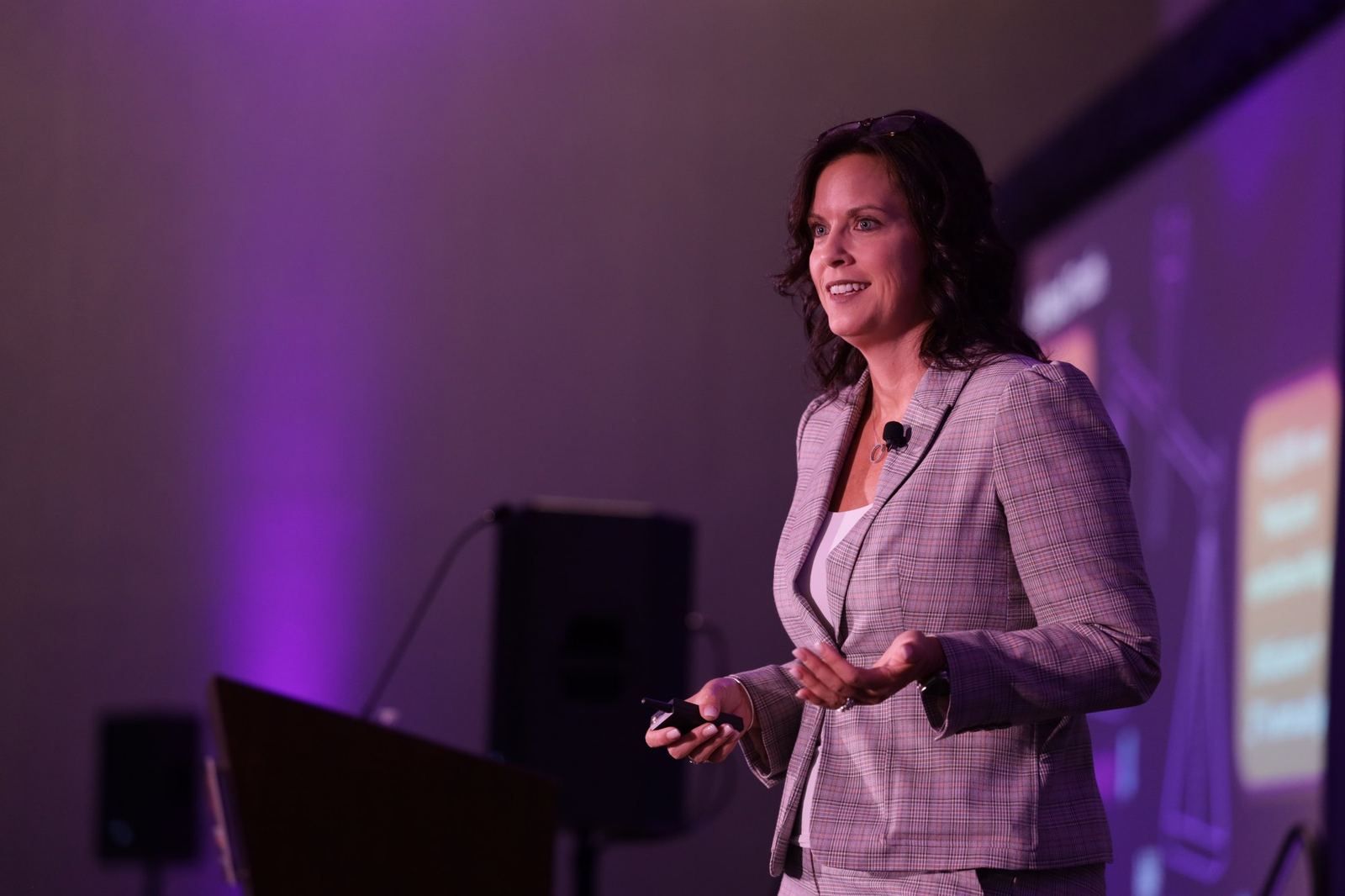 Speaker presenting on a lit stage to an audience